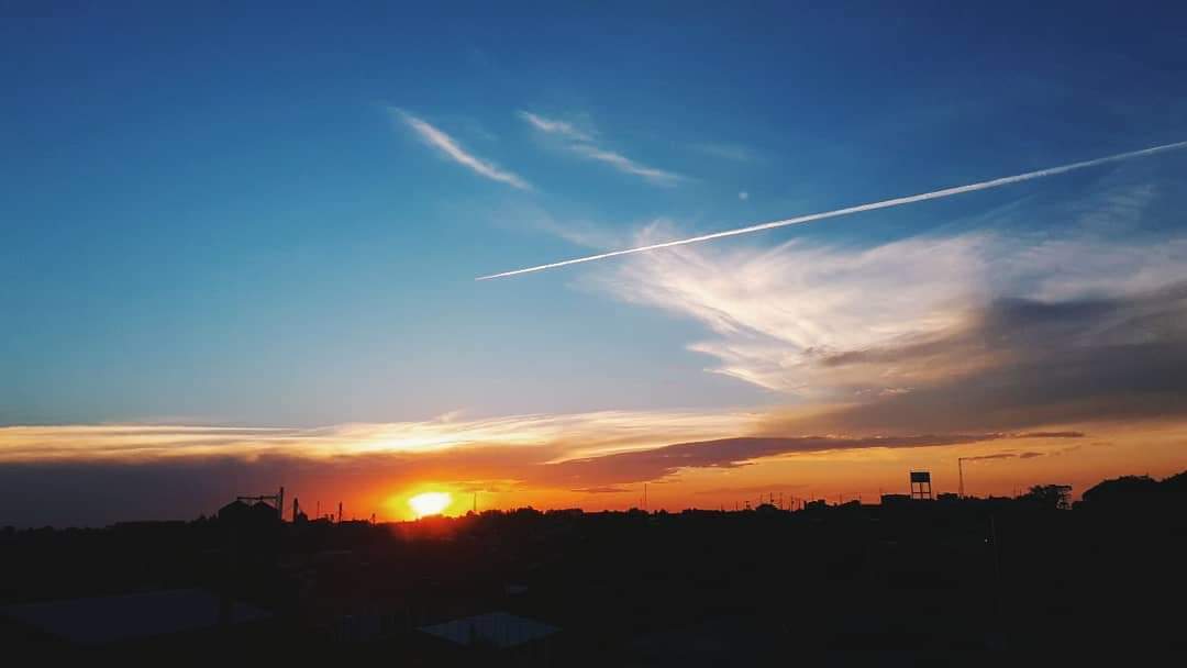 O nascer do sol em Campo Erê com rastro da passagem de um avião