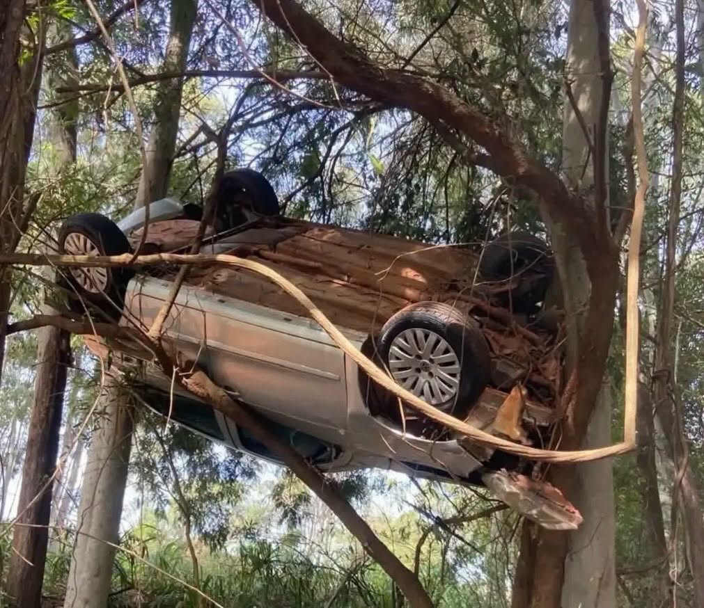 Inusitado: carro sai da pista, capota e fica pendurado em árvores no Norte do Paraná